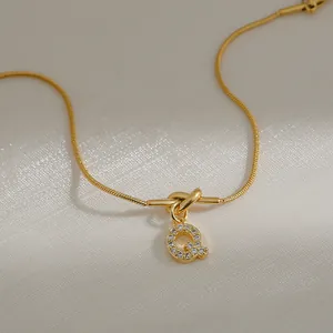Detail van de 18k gouden slangenketting met hanger letter Q bezet met zirkonia kristallen