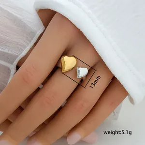 Detail showing 13mm width and 5.1g weight of two-tone heart open ring on finger