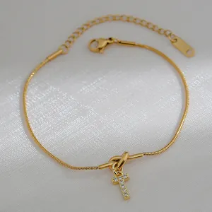 Detail van gouden slangenarmband met kristallen letter T-hanger en S925 zilveren stempel