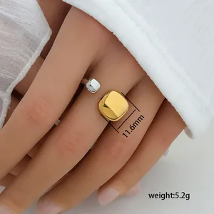 Detail of two-tone geometric open ring with polished gold and silver square elements