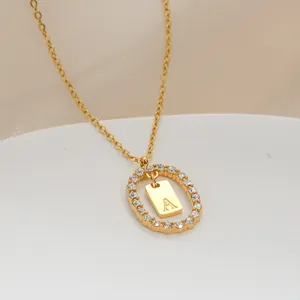 Dettaglio macro della collana placcata oro con ciondolo ovale cavo e lettera A in zircone