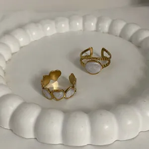 18K gold plated titanium geometric oval and heart ring set on white ceramic tray