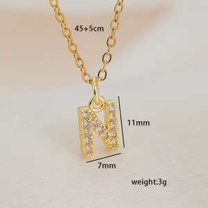 Close-up of golden letter N pendant necklace with micro-paved cubic zirconia crystals