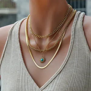 Close-up of layered gold chain necklaces with starburst pendant and blue stone detail