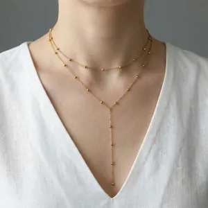 Elegant gold double-layered Y-shaped necklace with delicate beads on model