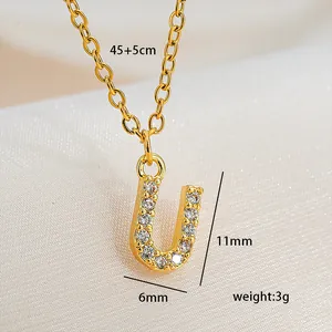 Detail of gold square letter U pendant necklace with sparkling cubic zirconia inlay