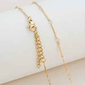 Macro detail of 18K gold plated necklace showing lobster clasp and adjustable extension chain