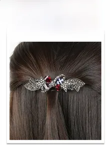 Detail of vintage bow hair clip with colorful rhinestones on a spring metal base