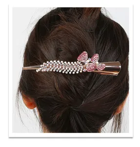 Detail of rose gold hair clip with pink and white rhinestones on dark hair