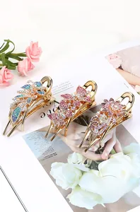 Three gold-plated butterfly and flower hair clips with colorful crystals and rhinestones