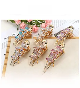 Detail of six colorful rhinestone butterfly hair clips with golden alloy base