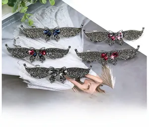 Detail showing five rhinestone butterfly hair clips in varied colors on a magazine background