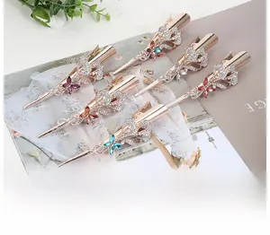 Detail of five rose gold hair clips with rhinestones in floral and butterfly designs