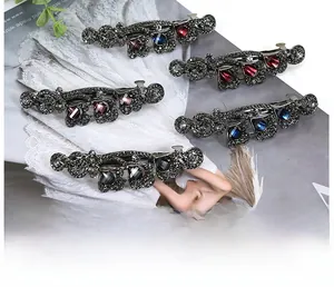 Detail of vintage bow hair clips with grey rhinestones and colorful crystal accents