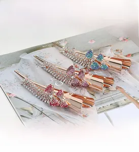 Detail of three alloy butterfly hair clips with sparkling rhinestones in red, purple and blue