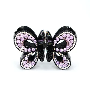 Pince à cheveux papillon élégante avec strass violets sur une base noire polie