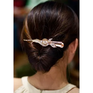 Elegant rose gold hair clip with rhinestones in floral design on a woman's bun