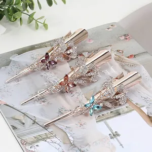 Three-piece set of elegant rose gold bow hair clips with colorful rhinestones on a magazine