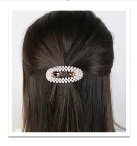 Detail of a handmade pearl hair clip with small beads and metal spring clip on hair