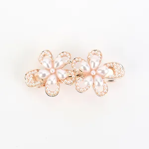 Elegant gold-tone dual flower hair clip with pearls and rhinestones on a clean white background