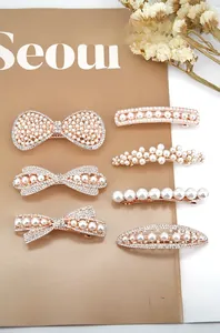 Macro detail of 6-piece rose gold pearl hair clips set with rhinestones and bows