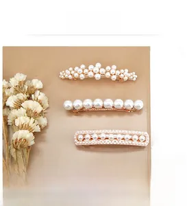 Detail view of pearl hair clips with rhinestone and golden alloy base for bridal styling