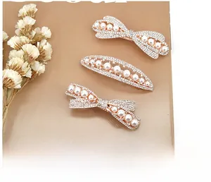 Detailed view of rose gold hair clips with white pearls and sparkling rhinestones