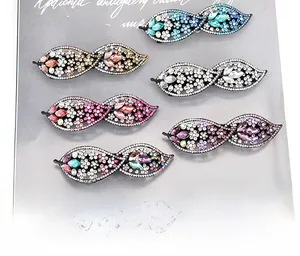 Detailed view of six colorful rhinestone bow hair clips in various sparkling crystal shades