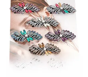 Detail showing elegant hollow bow hair clips with colorful rhinestones on alloy frame