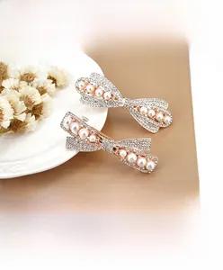 Detail view of rose gold hair clip with sparkling rhinestones and white pearls