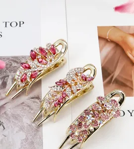 Close-up of golden floral hair claws with pink crystals and shimmering rhinestones