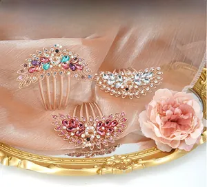 Detailed view of peacock hair combs with colorful rhinestones on a gold metal base