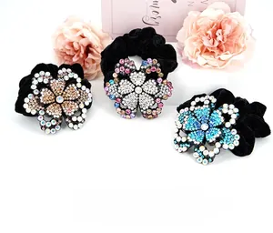 Close-up of three velvet hair ties with sparkling rhinestone encrusted flower details