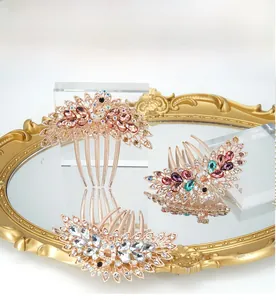 Detailed view of vintage peacock hair combs with colorful rhinestones on a mirror surface