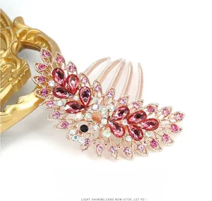 Macro detail of rose gold peacock hair comb with pink rhinestones and vintage carving