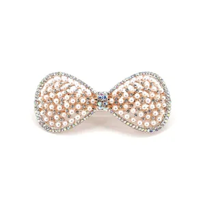 Elegant white pearl bow hair clip with sparkling rhinestones and gold-plated spring grip