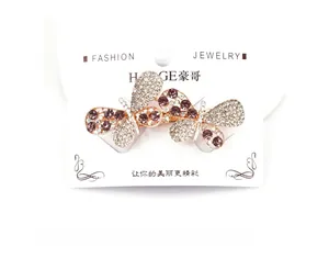 Detail of double butterfly hair clip with rhinestones and purple gems on display card