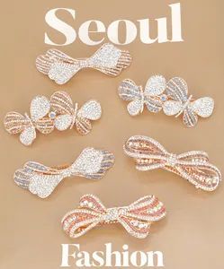 Detailed view of six sparkling butterfly and bow hair clips with inlaid rhinestones