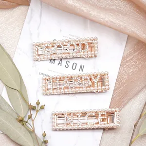 Set of three gold-plated hair clips with pearls and rhinestones spelling GOOD HAPPY NICE