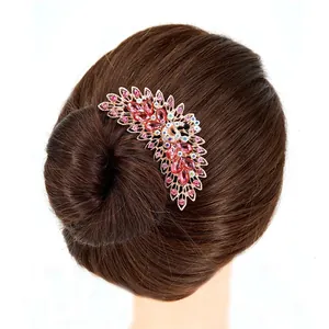 Peacock crystal hair comb with pink rhinestones and rose gold base on dark hair bun