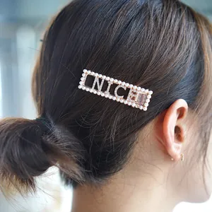 Golden metal hair clip with pearls and NICE rhinestone letters worn on hair