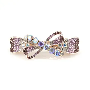 Elegant bow hair clip with purple and AB rhinestones on a gold metal spring clasp