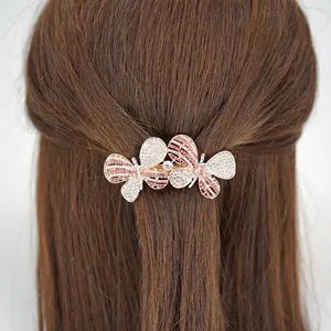 Sparkling butterfly hair clip with pink rhinestones on a rose gold base worn by a model