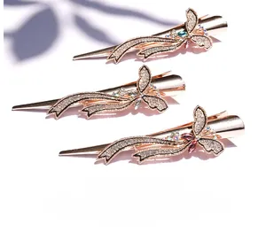 Détail de trois barrettes papillon en or rose avec strass brillants et rubans élégants