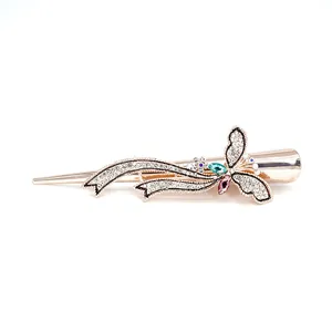 Pince à cheveux papillon dorée avec strass roses et verts sur fond blanc