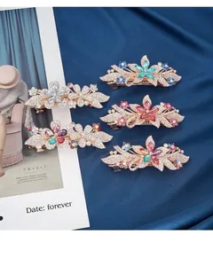 Detailed view of sparkling flower spring hair clips with crystals on blue satin fabric