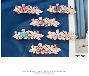 Detail showing six colors of rhinestone flower hair clips with gold alloy base on blue silk