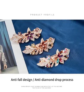 Detailed view of floral spring hair clips with sparkling rhinestones on blue silk