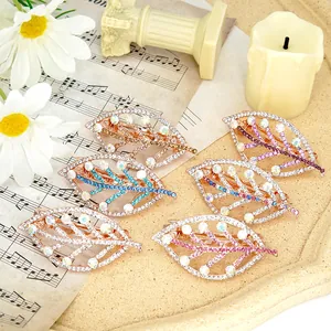 Set of six hollow leaf-shaped crystal hair clips in various colors on a vintage tray