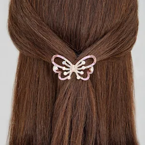 Elegant butterfly hair clip with pink crystal rhinestones on dark brown hair